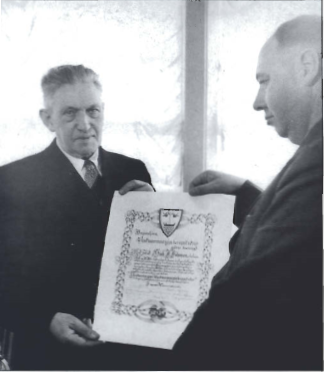Mynd:Bœjarstjórn Vestmannaeyja kaus Gísla J. Johnsen heiðursborgara Vestmannaeyja á sjötugsafmœli hans 1951. Hér afliendir Helgi Benediktsson forseti bœjarstjórnar Gísla skjal því til staðfestingar.png